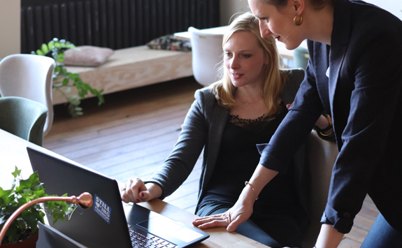 Two people looking at a laptop screen.